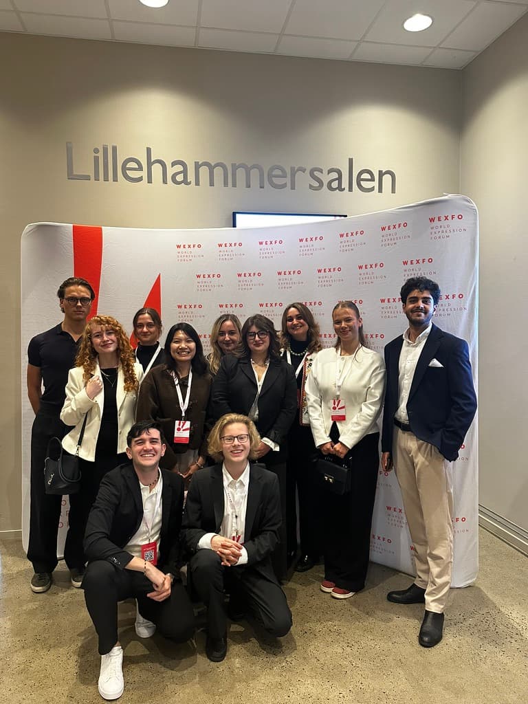Justus August (links) mit weiteren Debattenteilnehmern vor der World-Expression-Forum-Wand beim WEXFO 2026, Lillehammer